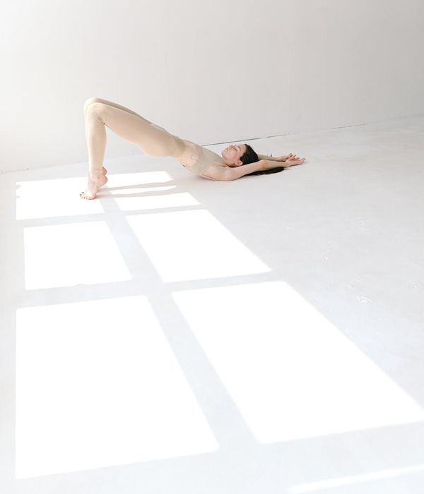 Pregnant woman in a peaceful yoga pose in a bright studio.